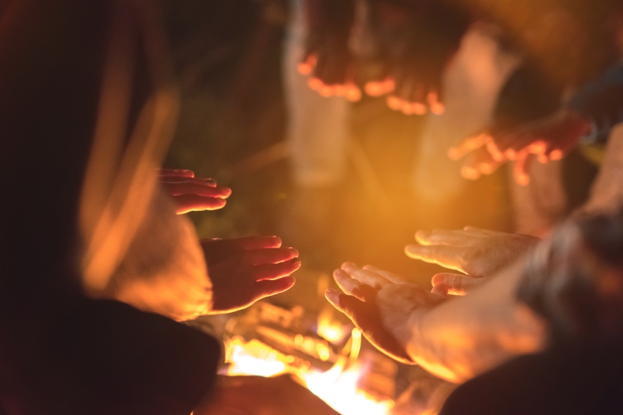 people warming themselves around a fire